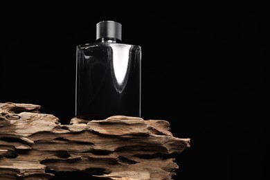 Photo of Luxury men`s perfume in bottle against black background, low angle view. Space for text