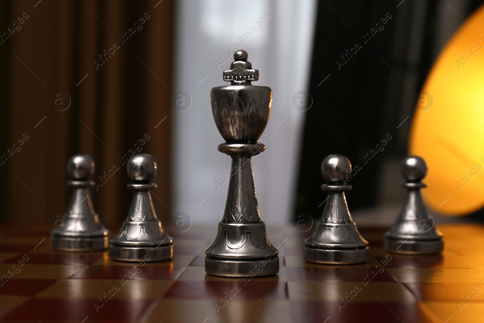 Photo of King and pawn pieces on chessboard indoors