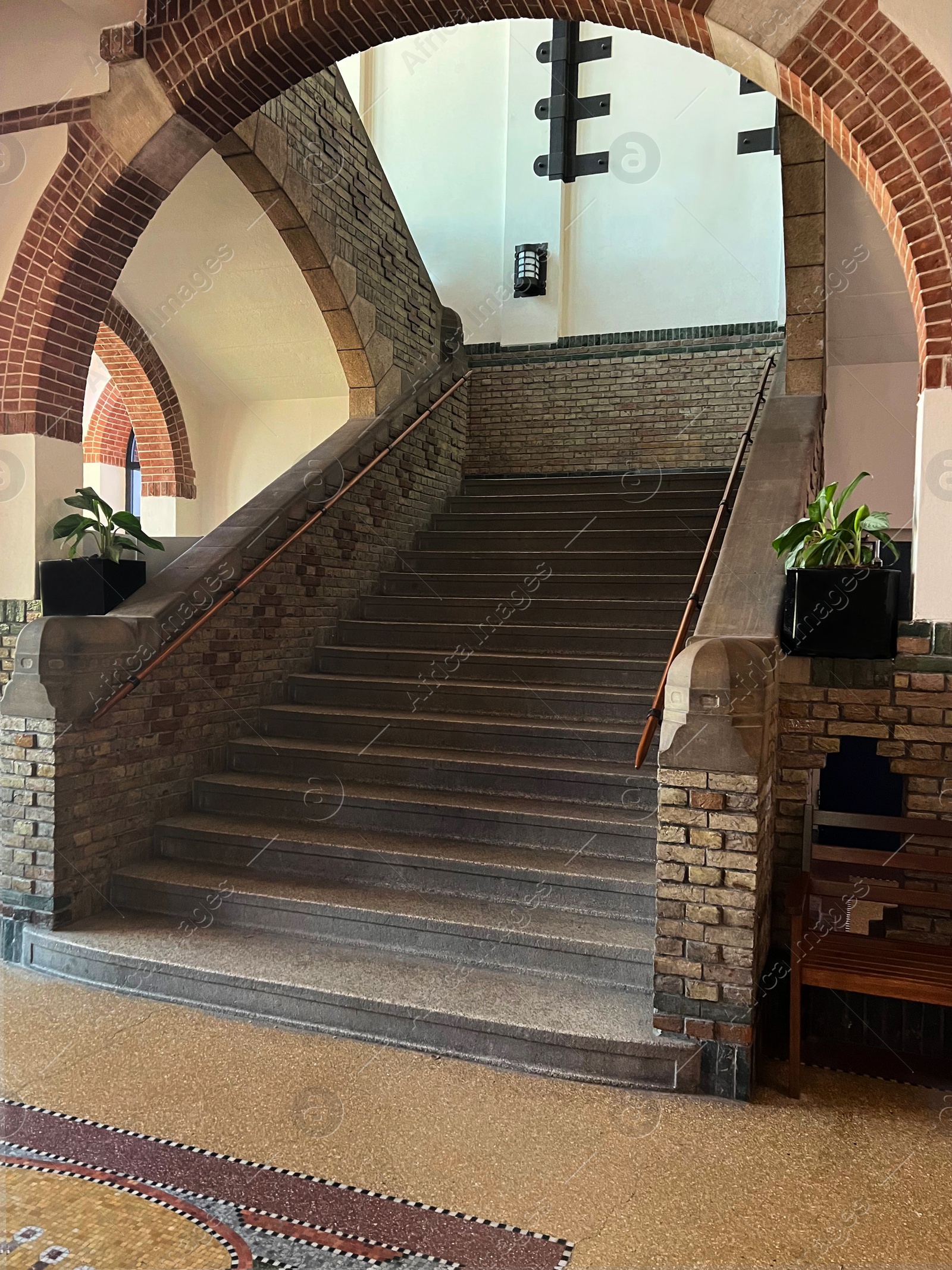 Photo of School hallway interior with arch above stone staircase