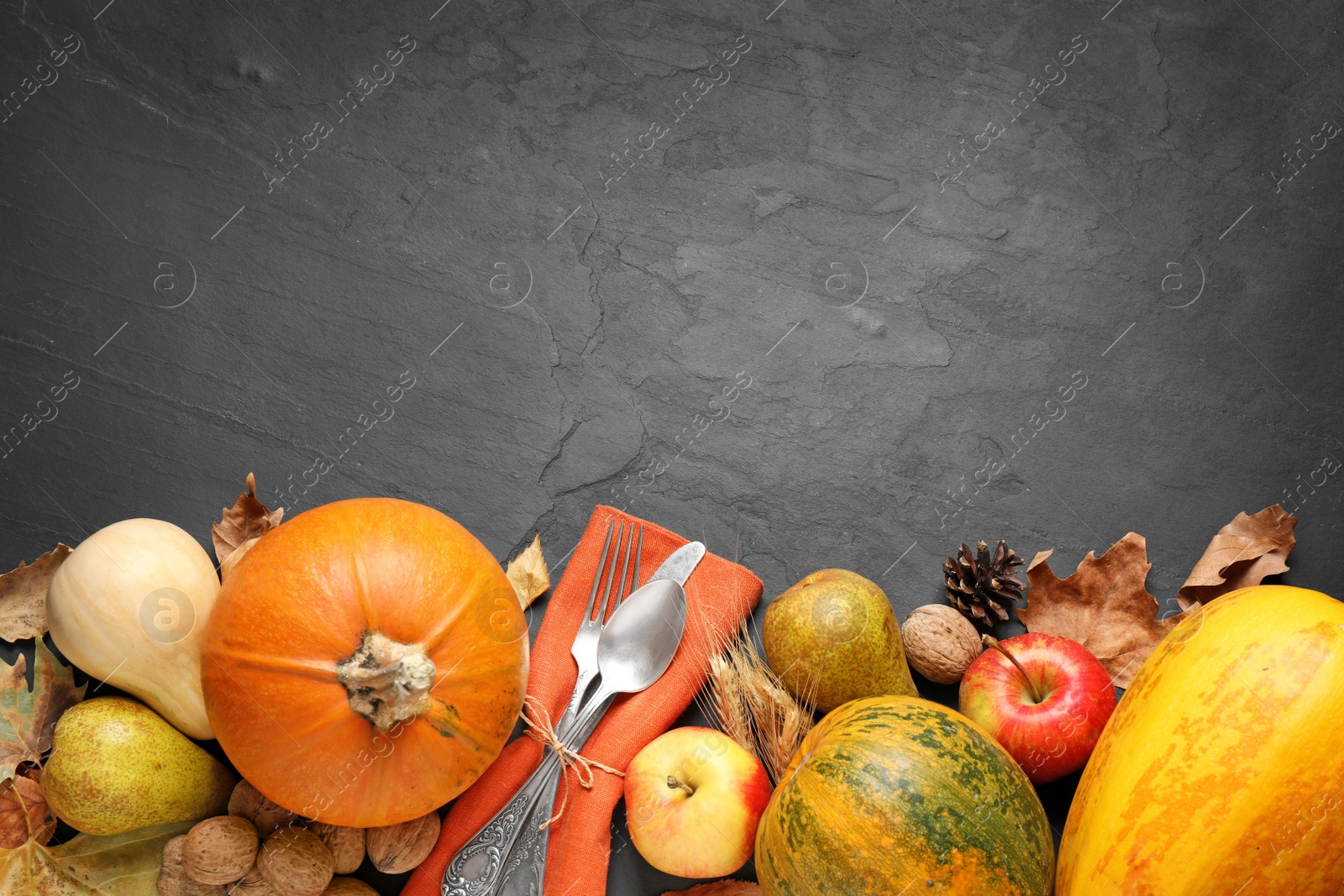 Photo of Flat lay composition with cutlery, autumn vegetables and fruits on grey background, space for text. Happy Thanksgiving day