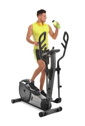 Man with bottle on modern elliptical machine against white background