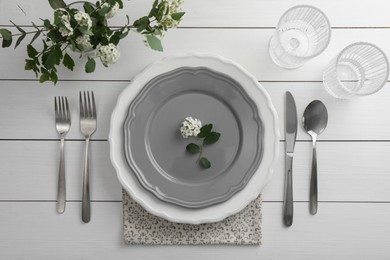 Photo of Stylish setting with cutlery, glasses and plates on white wooden table, flat lay