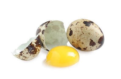 Whole and cracked quail eggs on white background