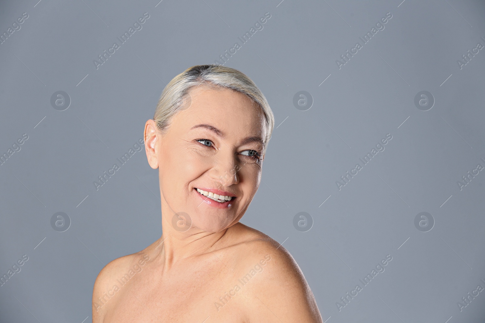 Photo of Portrait of beautiful mature woman on grey background