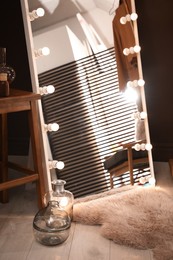 Stylish mirror with light bulbs in room. Interior design