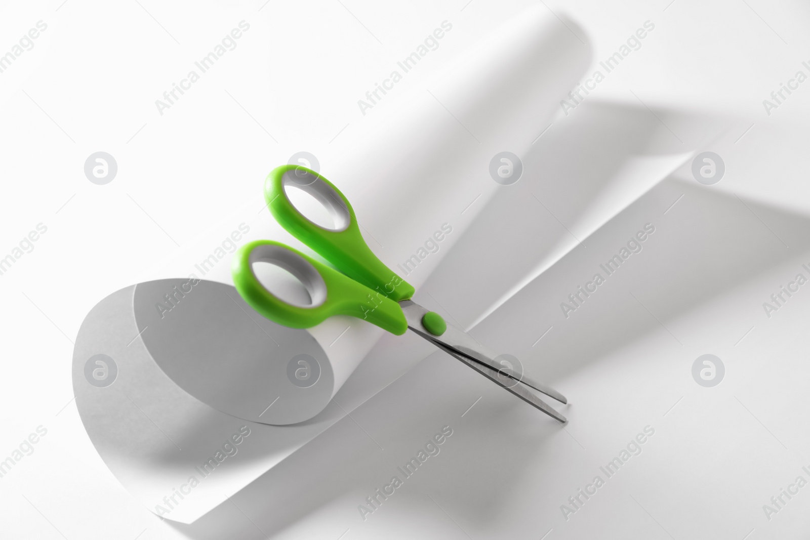 Photo of Green scissors and paper on white background