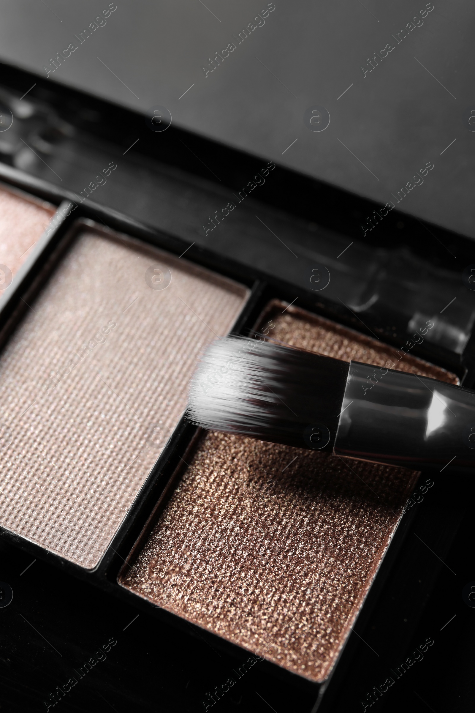 Photo of Beautiful eye shadow palette with brush on grey table, closeup