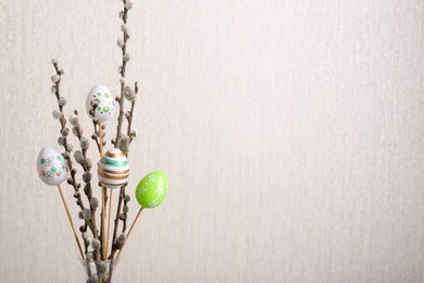 Beautiful willow branches with painted eggs on light grey background, space for text. Easter decor