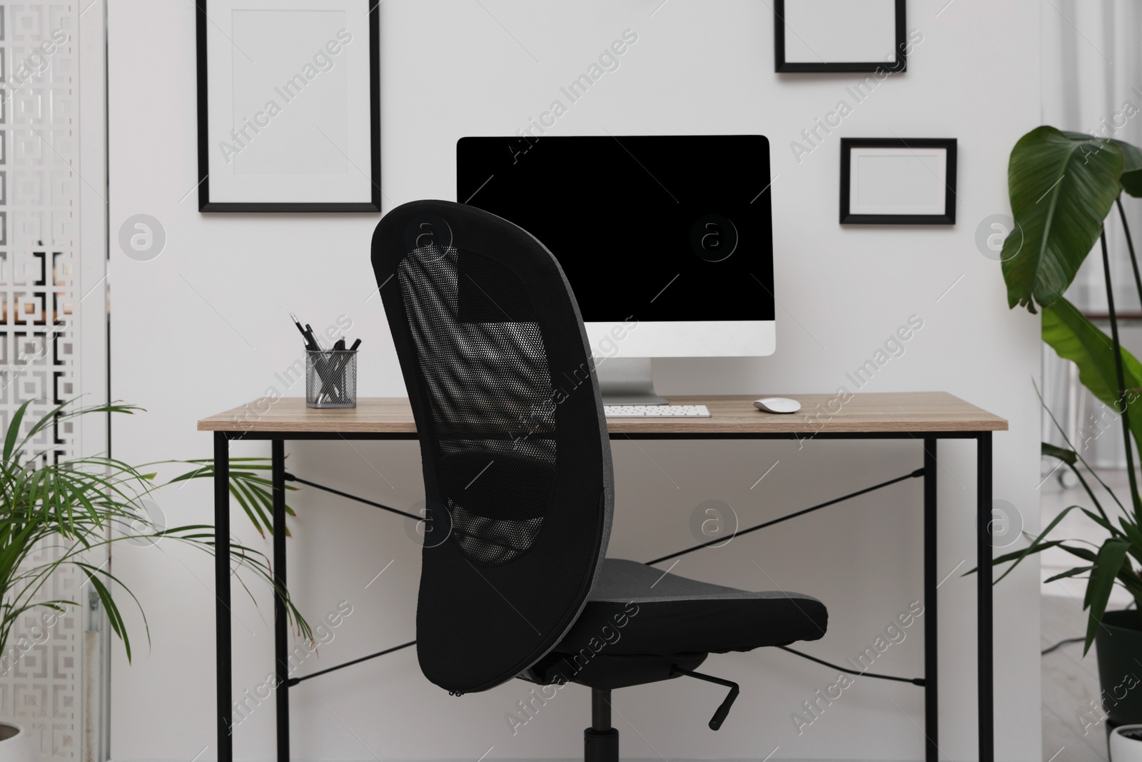 Photo of Comfortable office chair near desk in modern workplace