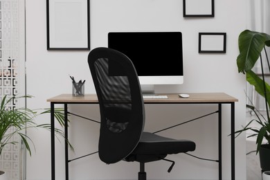 Comfortable office chair near desk in modern workplace