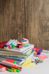 Photo of Many different books, paper plane and school stationery on white table. Back to school