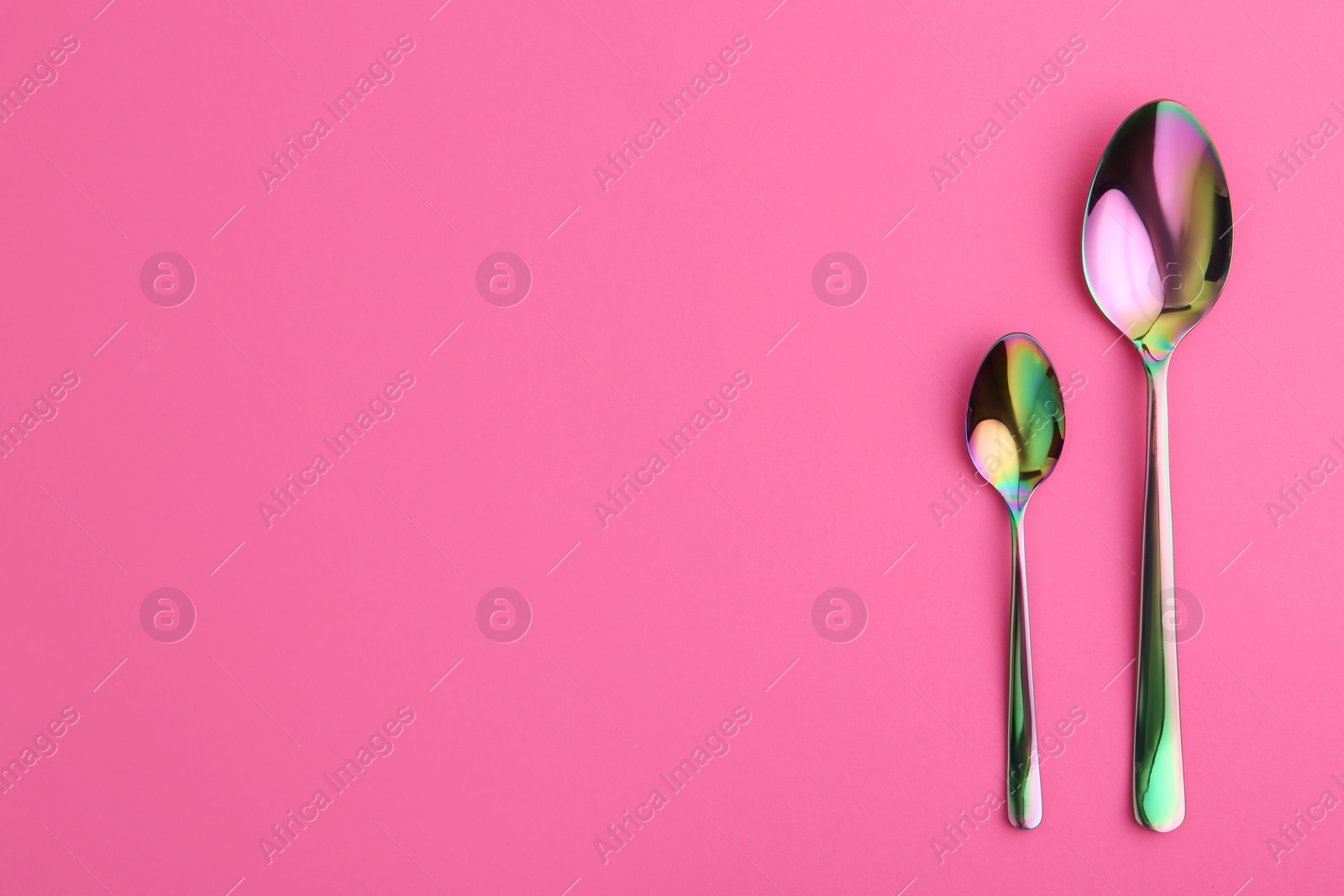 Photo of Clean spoons and space for text on color background, flat lay