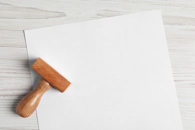 Blank sheet of paper and visa stamp on white wooden table, top view