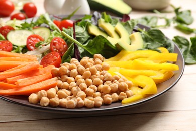 Balanced diet and vegetarian foods. Plate with different delicious products on wooden table, closeup