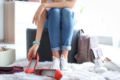 Photo of Young woman trying on shoes in store