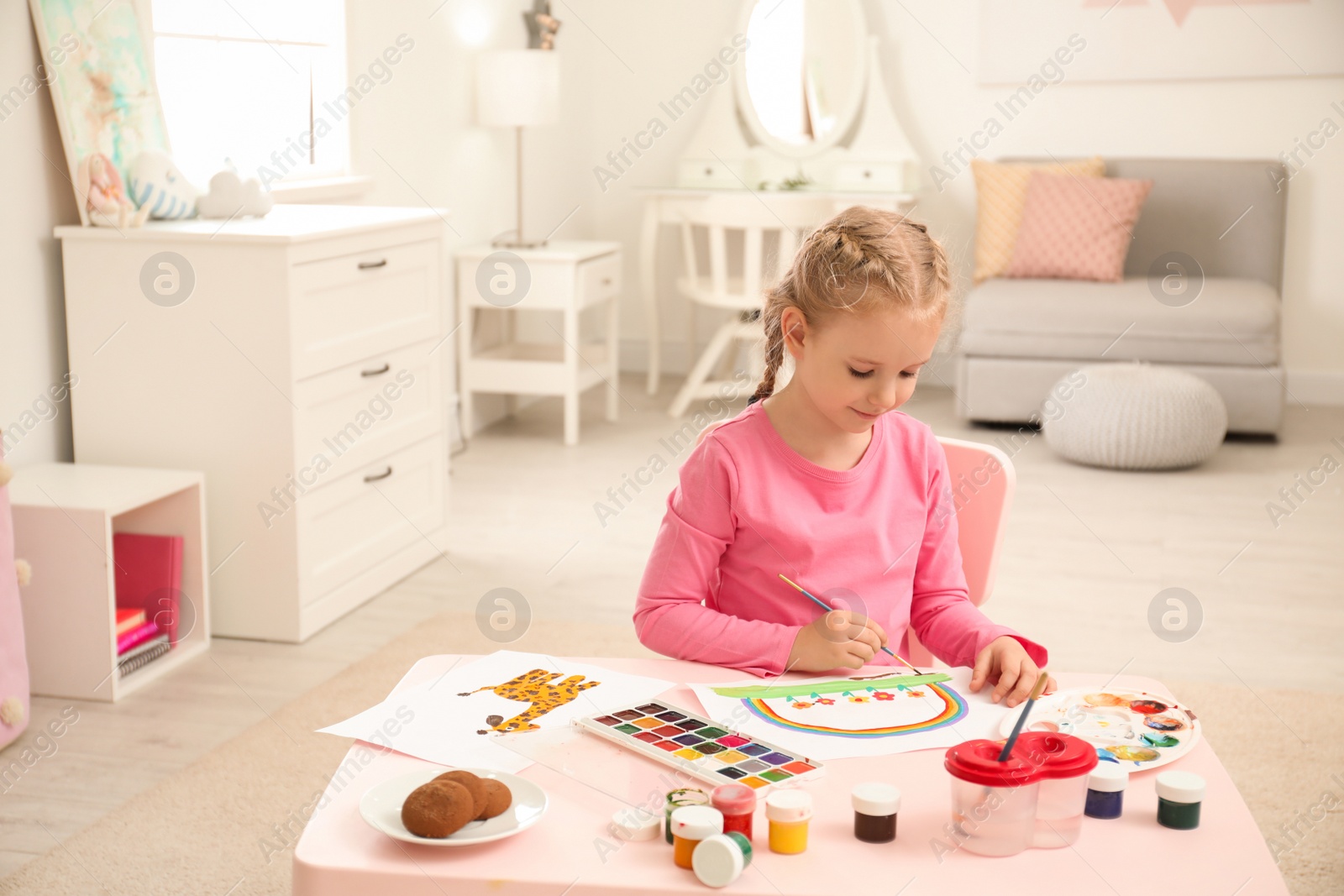 Photo of Cute little child painting at table in room