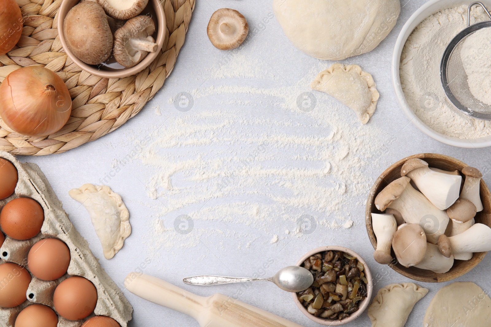 Photo of Process of making dumplings (varenyky) with mushrooms. Frame made of ingredients on white table, flat lay. Space for text