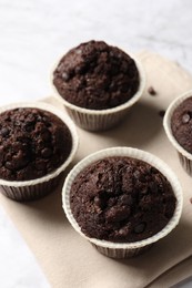 Tasty chocolate muffins on white table, closeup