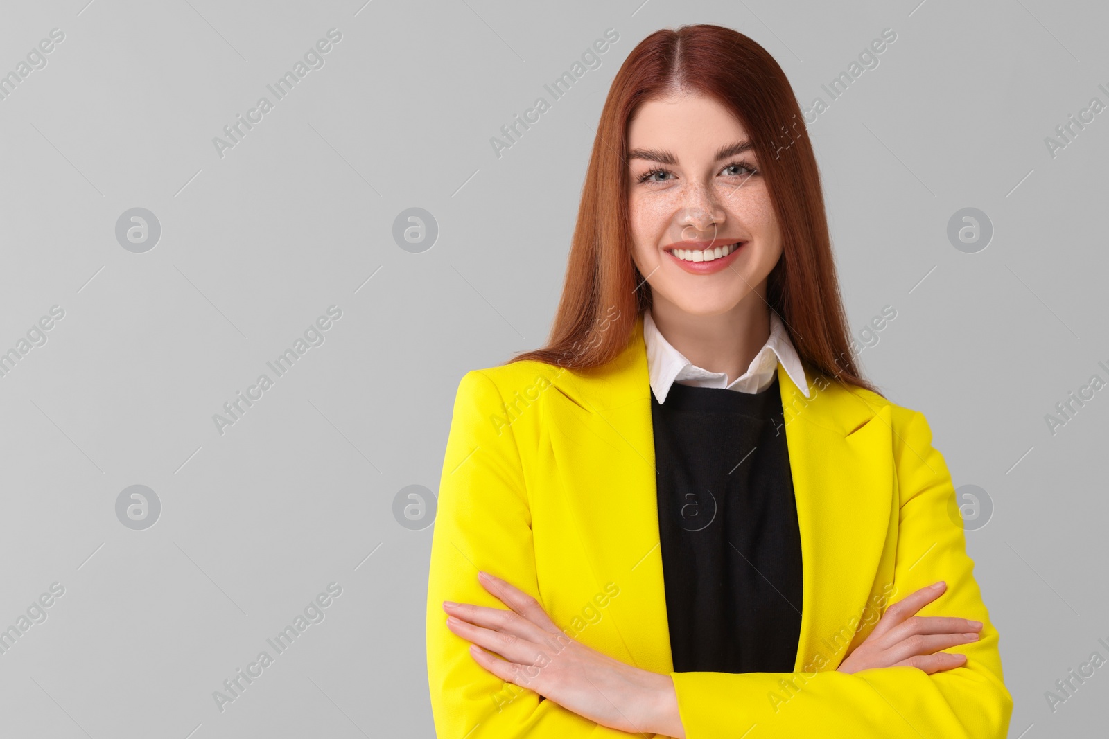 Photo of Portrait of smiling woman with crossed arms on light grey background. Space for text