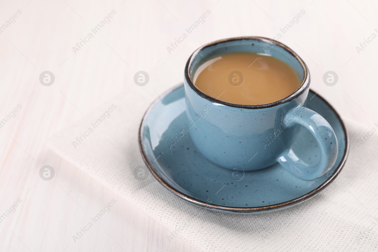 Photo of Delicious coffee in cup on white wooden table, closeup. Space for text