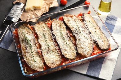 Photo of Baked eggplant with tomatoes and cheese in dishware on table