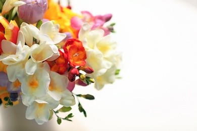 Photo of Beautiful bouquet of freesia flowers on light background