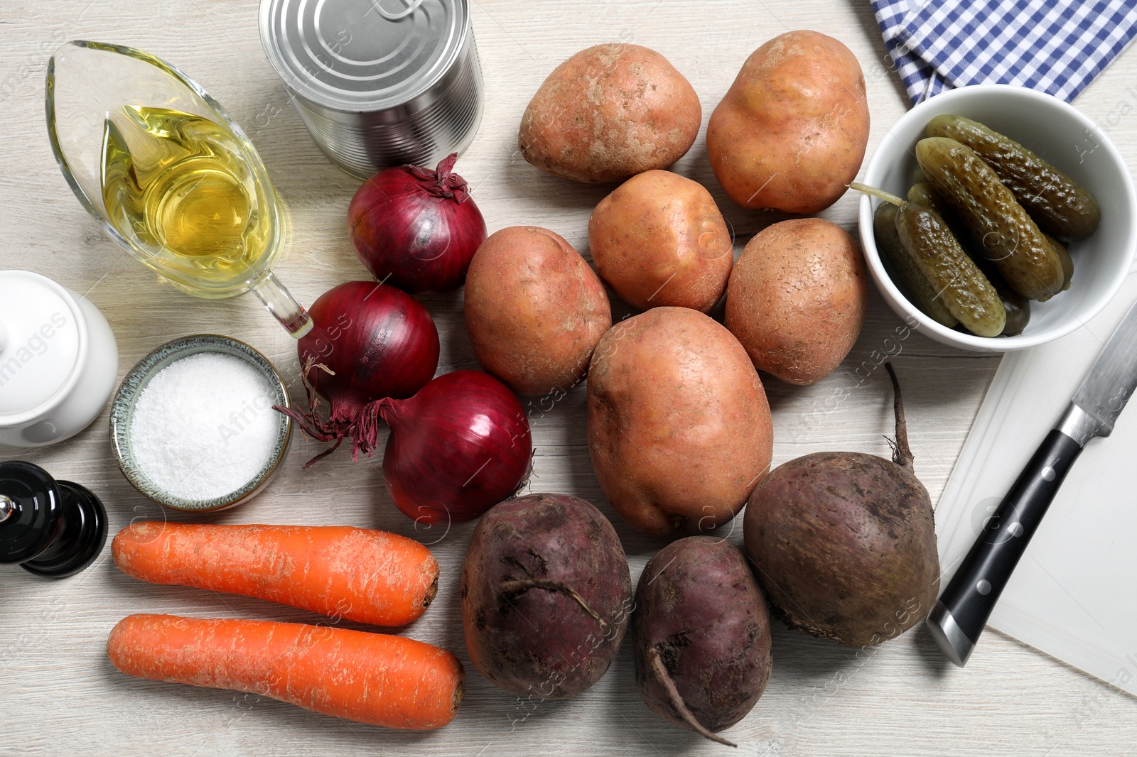 Photo of Many fresh vegetables and other ingredients on white wooden table, flat lay. Cooking vinaigrette salad