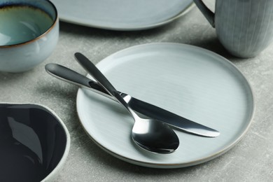 Photo of Stylish empty dishware and cutlery on light grey table, closeup