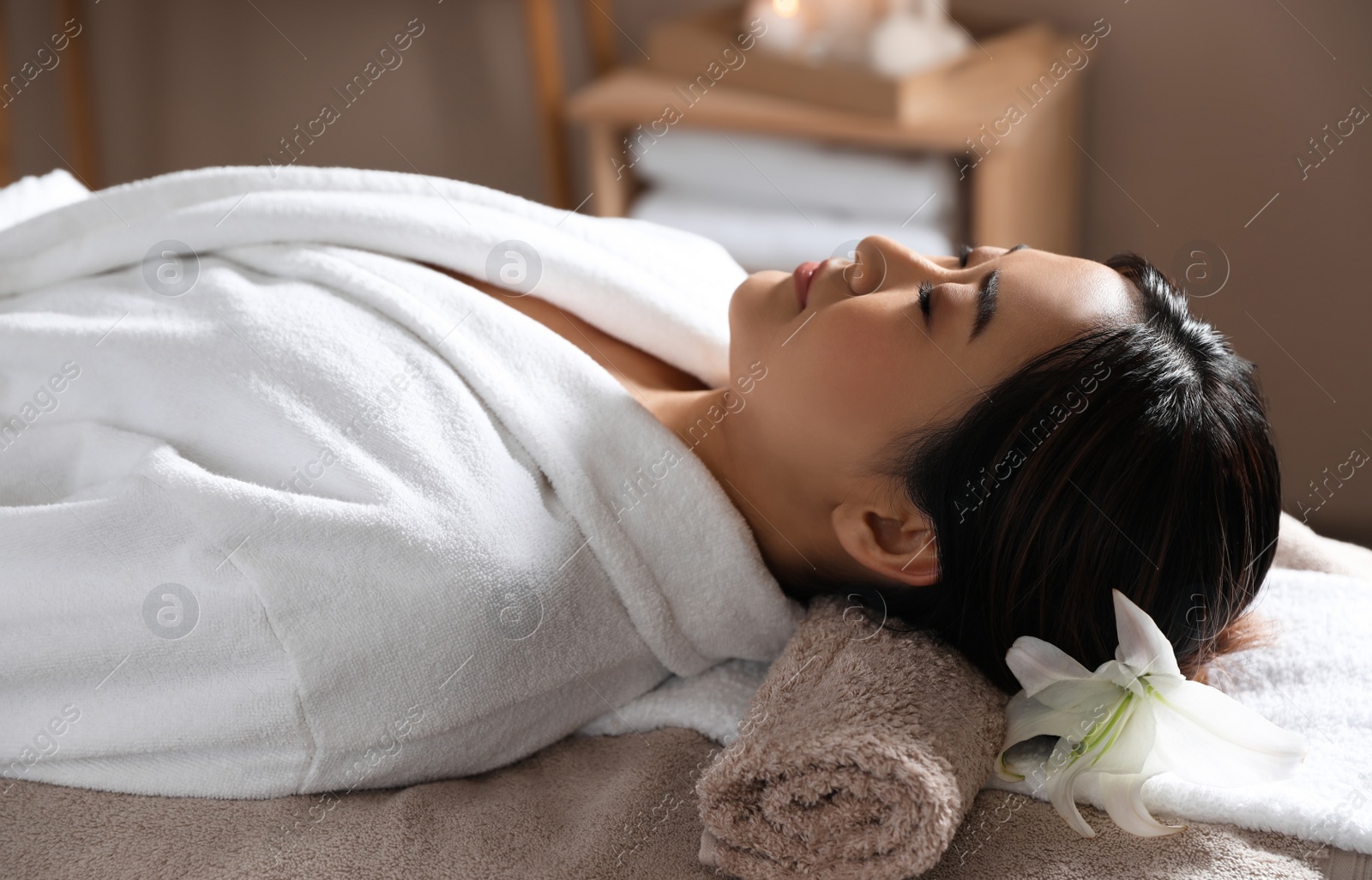 Photo of Beautiful Asian woman lying on massage table in spa salon