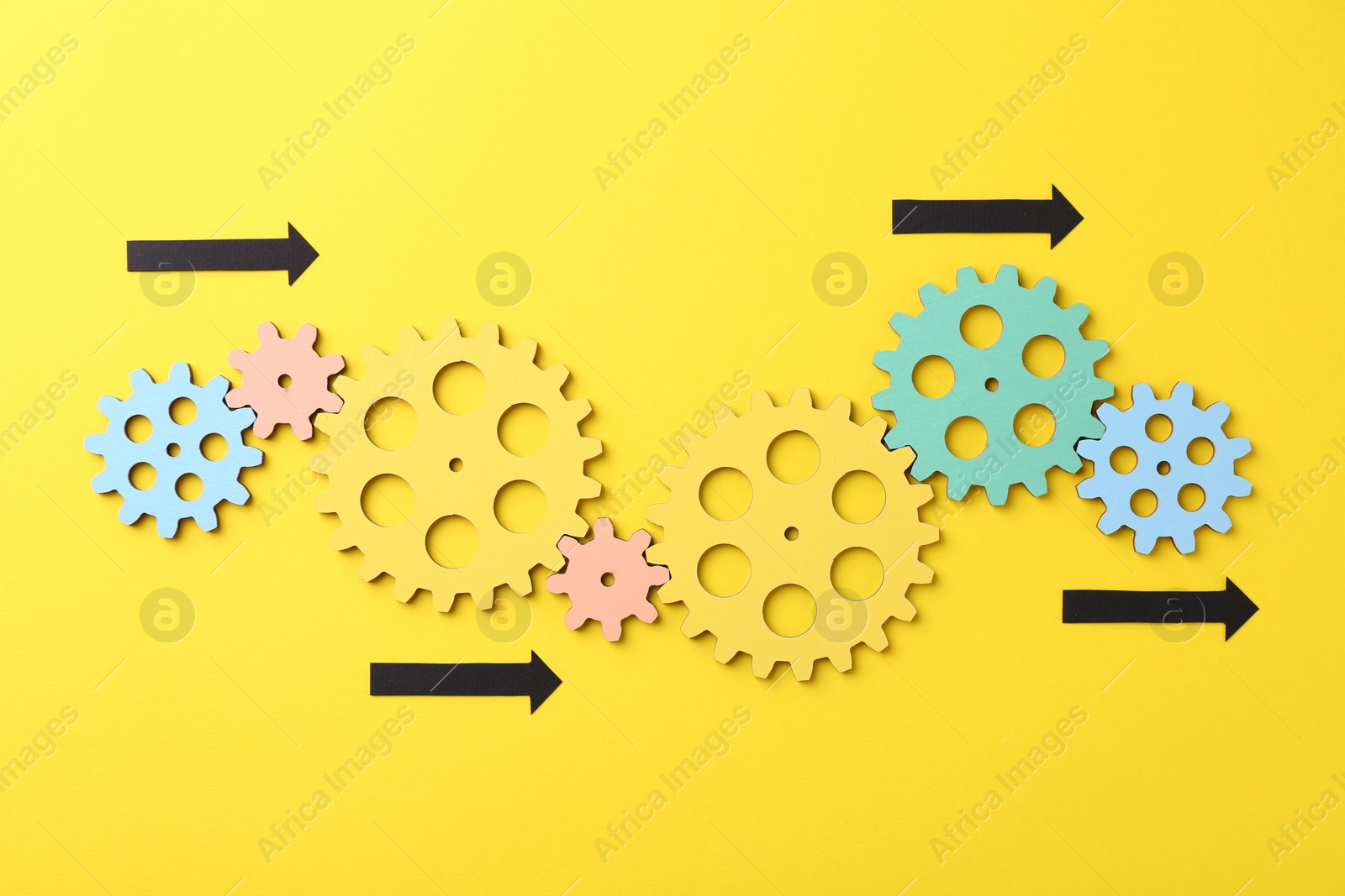 Photo of Business process organization and optimization. Scheme with wooden figures and arrows on yellow background, top view