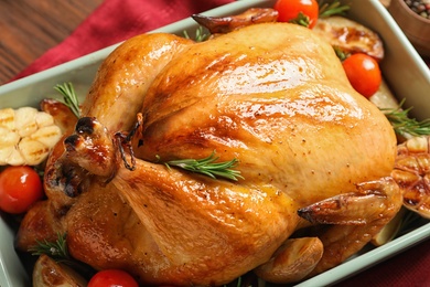 Photo of Cooked turkey with vegetables and rosemary in dish on table, closeup