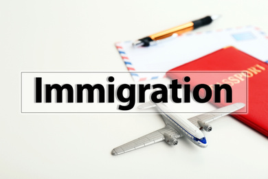 Toy plane and passport on white background. Immigration concept