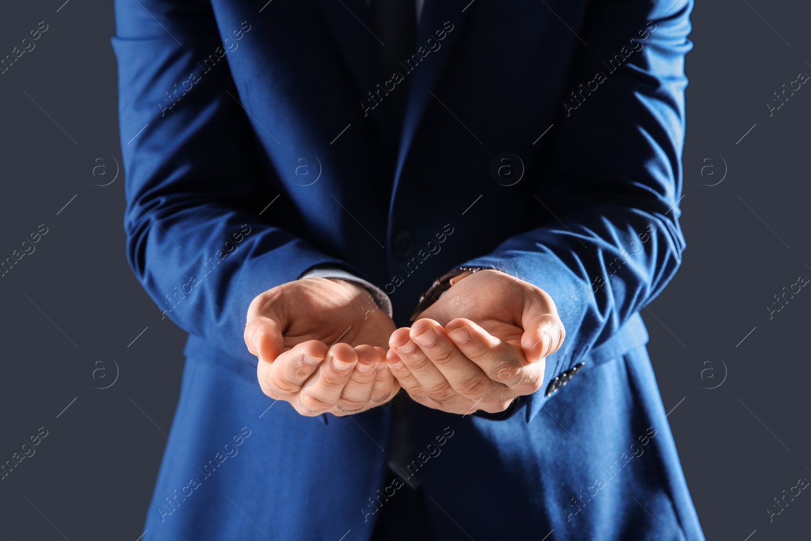 Photo of Businessman holding something in hands on dark background