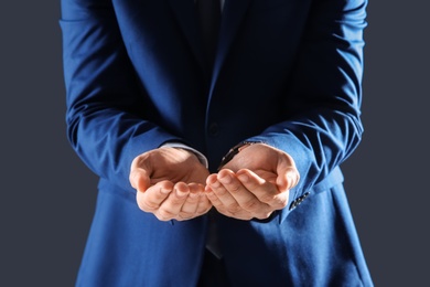 Businessman holding something in hands on dark background