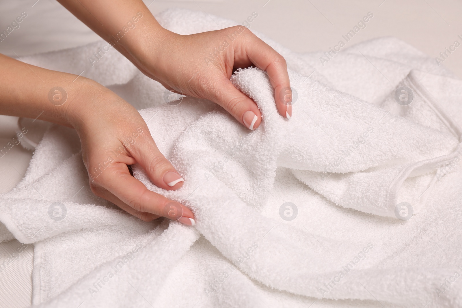 Photo of Woman touching soft white towel, closeup view