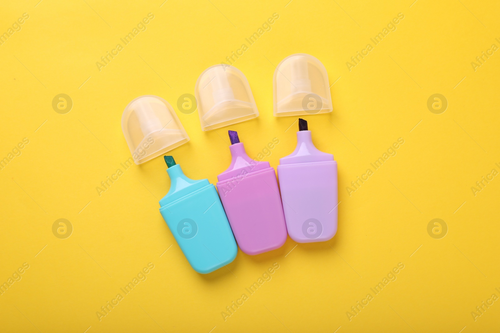 Photo of Many colorful markers on yellow background, flat lay