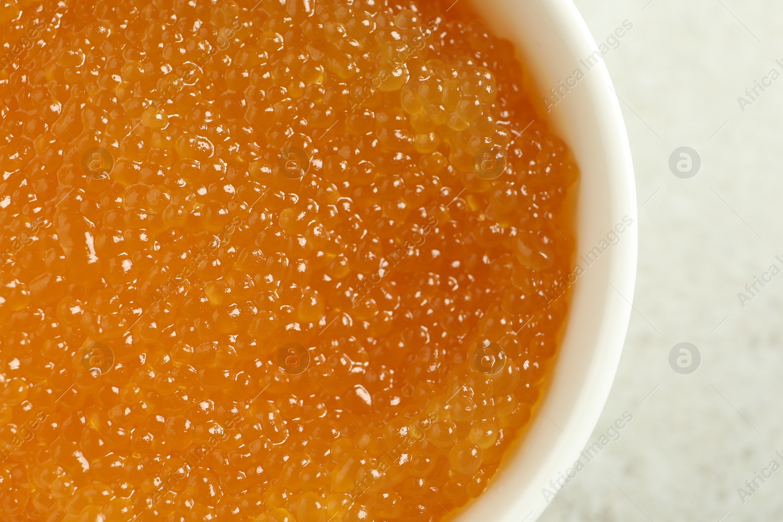 Photo of Fresh pike caviar in bowl on light grey table, closeup