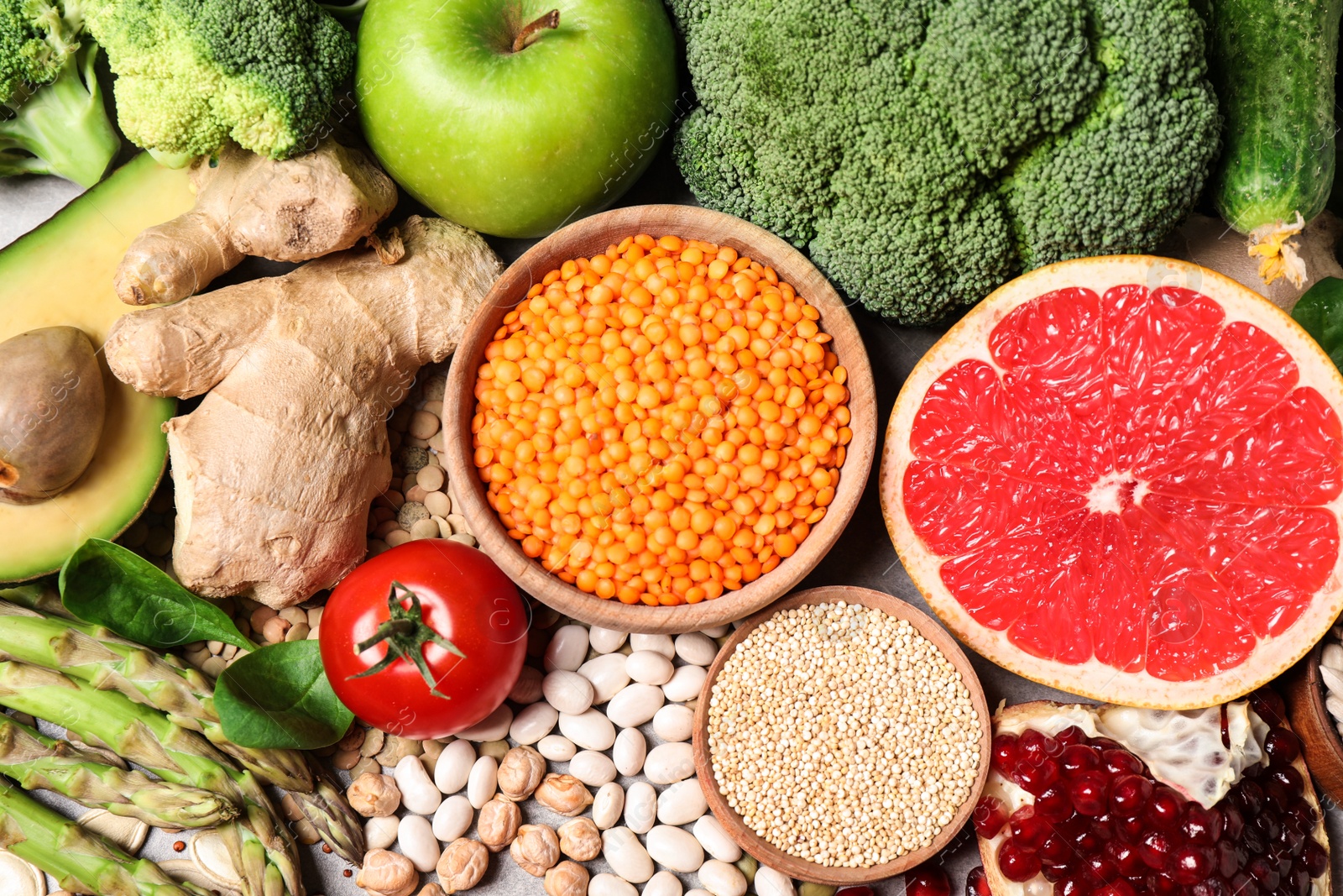 Photo of Fresh vegetables, fruits and seeds on grey table, flat lay