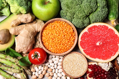 Fresh vegetables, fruits and seeds on grey table, flat lay