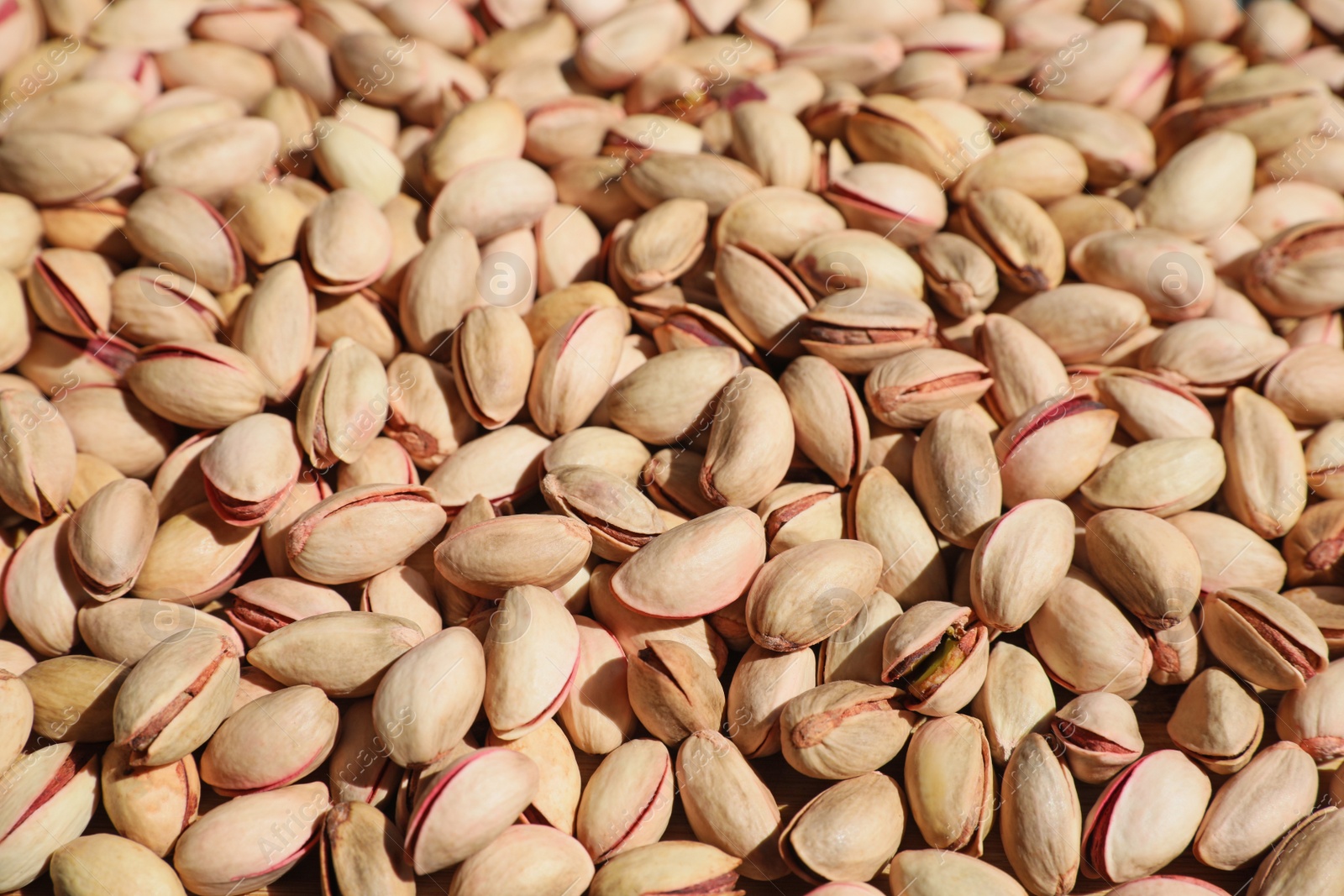 Photo of Many tasty pistachios as background, closeup view