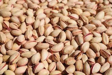 Many tasty pistachios as background, closeup view