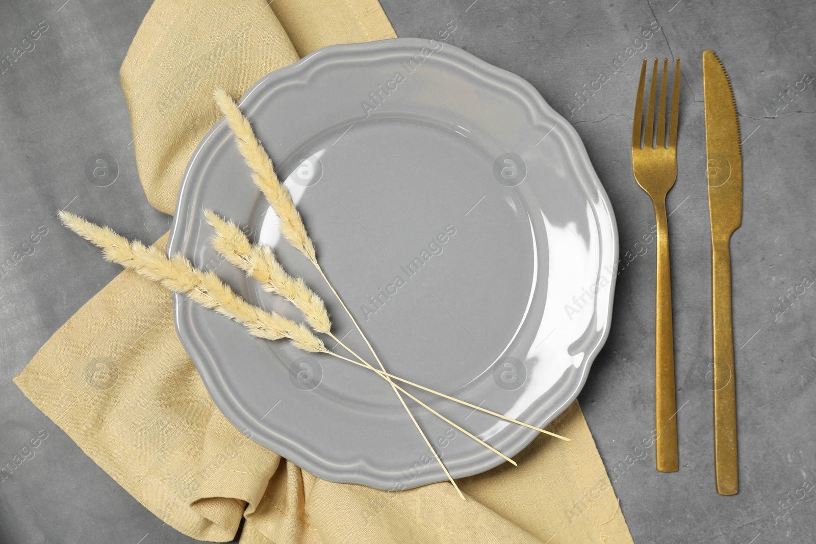 Photo of Stylish setting with elegant cutlery on dark grey table, top view