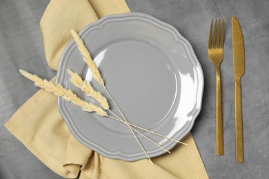 Stylish setting with elegant cutlery on dark grey table, top view