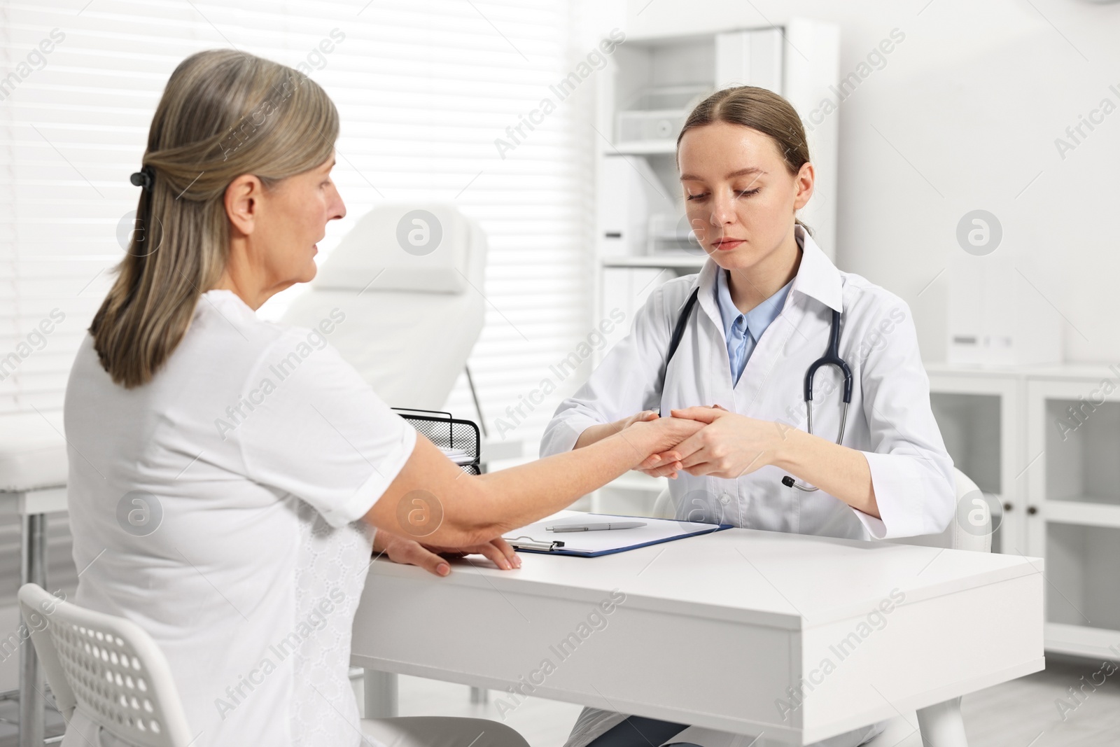 Photo of Arthritis symptoms. Doctor examining patient's wrist in hospital