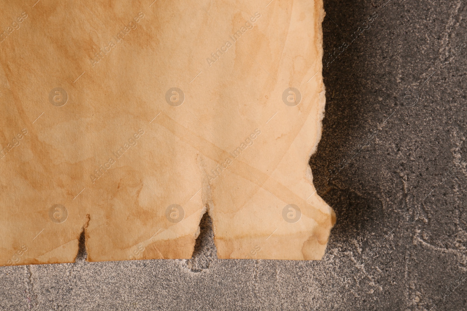 Photo of Sheet of old parchment paper on gray textured table, top view