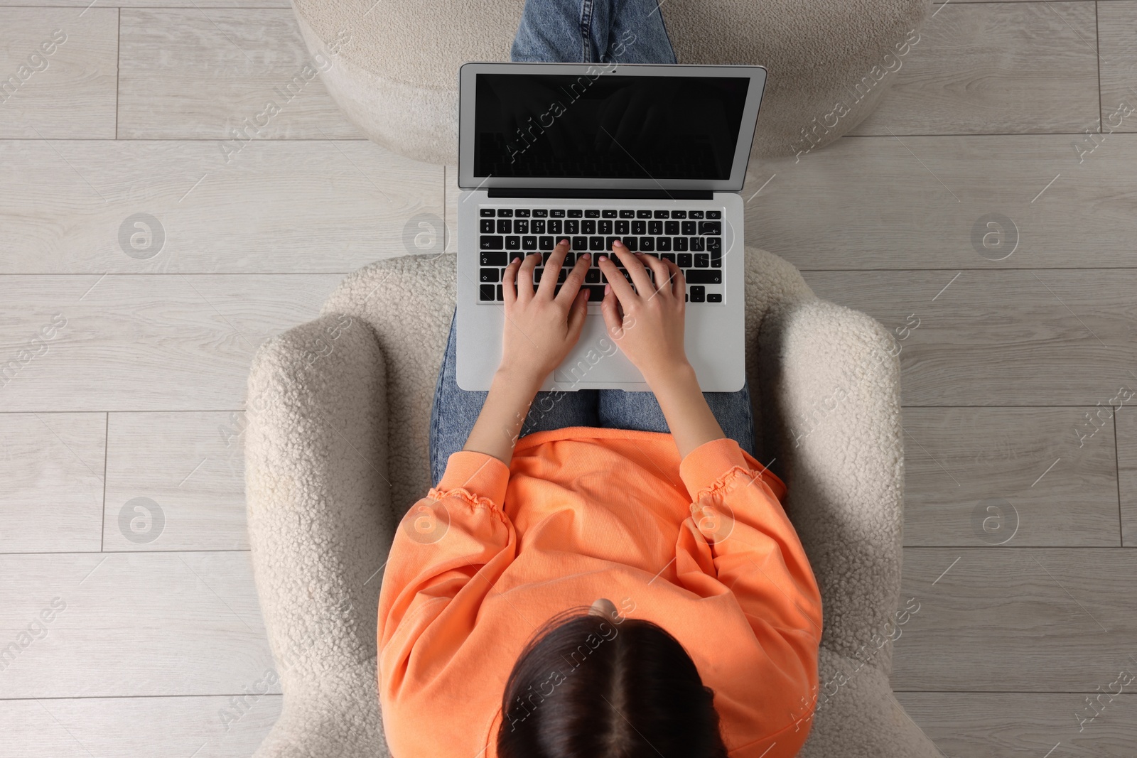 Photo of Woman working with laptop in armchair, top view