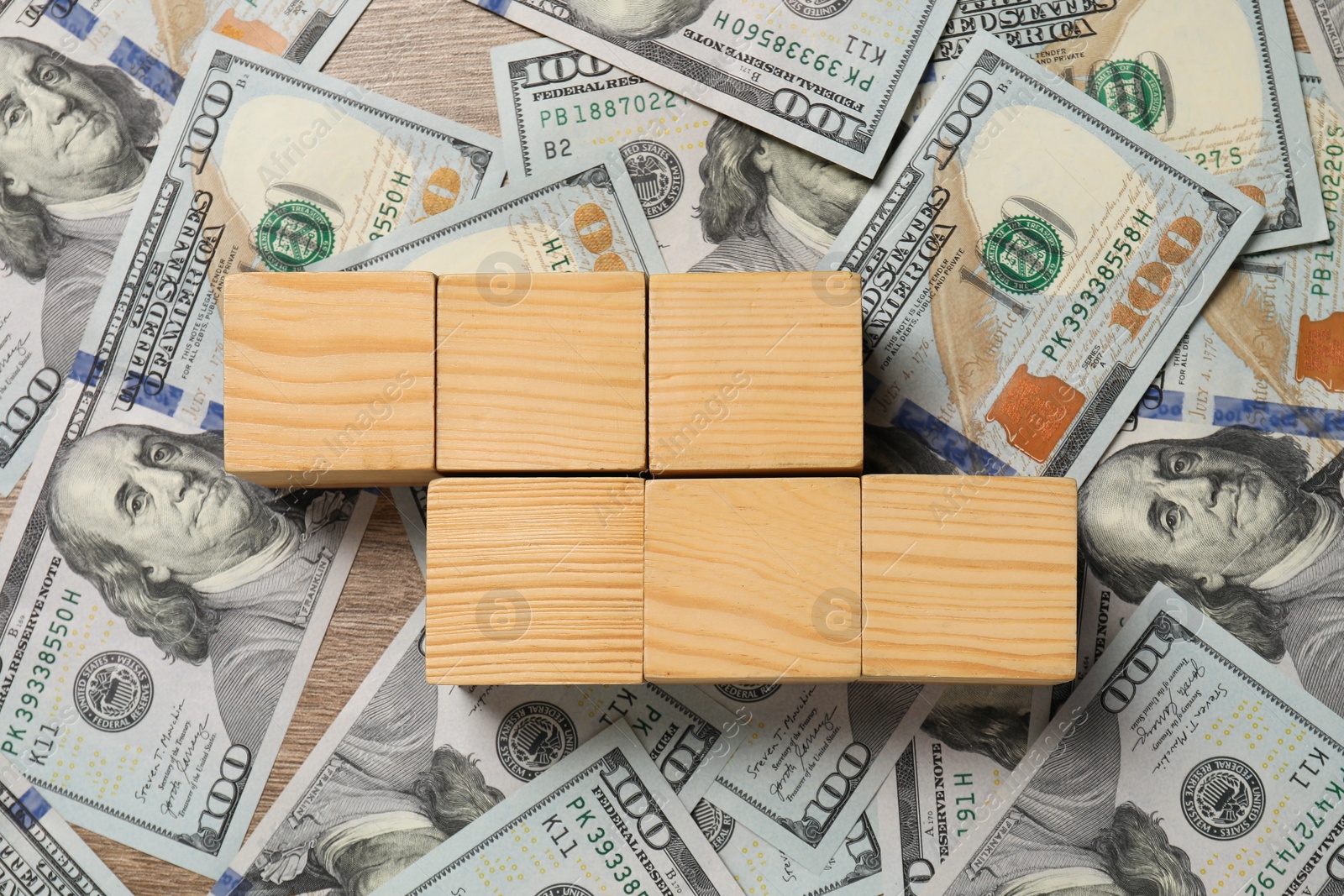 Photo of Blank wooden cubes and dollar banknotes on table, top view