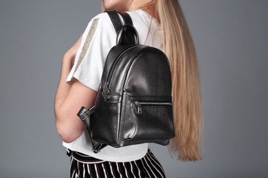 Photo of Woman with stylish backpack on grey background