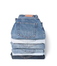 Stack of different folded jeans isolated on white