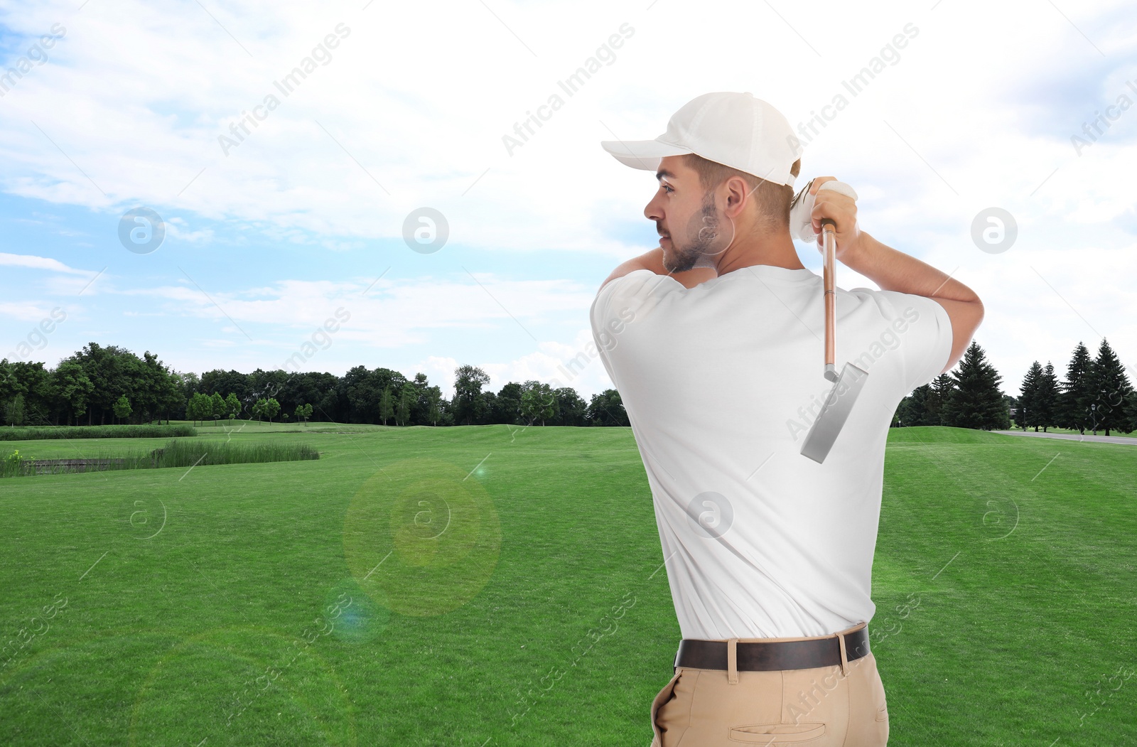 Image of Young man playing golf on course with green grass. Space for design